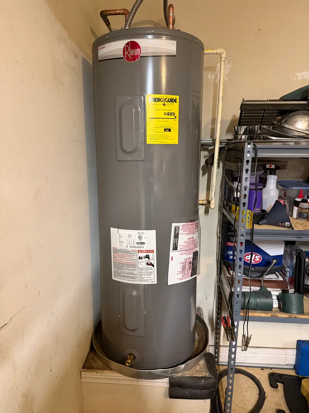 Rheem Professional water heater installed by Roach Plumbing & Heating, dated name plate visible