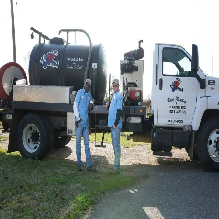 Two Roach Plumbing & Heating staff beside a branded service truck in Shreveport